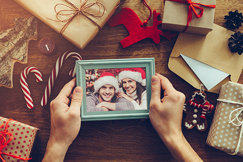 Christmas together. Top view of Christmas decorations and photograph in picture frame laying on the rustic wooden grain